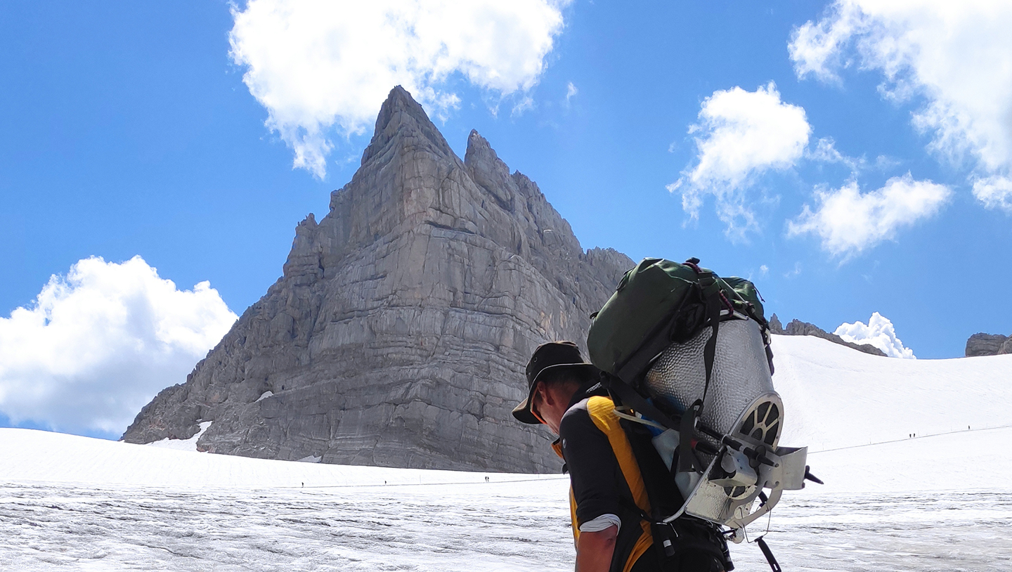 Person mit Forschungsausrüstung auf dem Hallstätter Gletscher im Dachsteinmassiv.